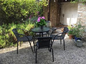 a table and chairs with a vase of flowers on it at Rose Cottage in Bakewell