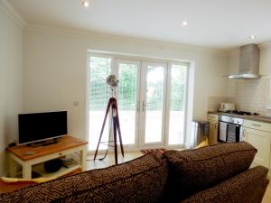 a living room with a couch and a camera on a tripod at The Hideaway in Verwood