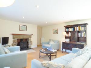 a living room with two couches and a fireplace at Farm Cottage in Saint Erth