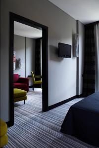 a bedroom with a mirror and a room with a tv at Twentyone Hotel in Rome