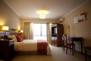 Habitación de hotel con cama, escritorio y TV. en Ayres De Salta Hotel en Salta
