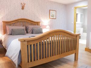 a bedroom with a wooden bed with a wooden crib at Gardener's Lodge in Nantwich