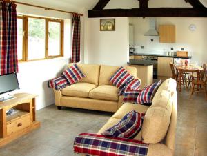 ein Wohnzimmer mit einem Sofa und einer Küche in der Unterkunft The Roost in Stratford-upon-Avon