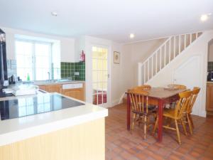 a kitchen with a table and chairs in a kitchen at Farm Cottage in Saint Erth