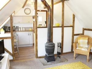 a kitchen with a stove in the middle of a room at The Hayloft in West Bradenham