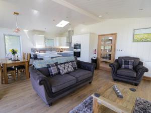 a living room with a couch and a kitchen at Squirrel Lodge in Skipton