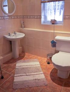 een badkamer met een wit toilet en een wastafel bij Sunrise in Lowestoft