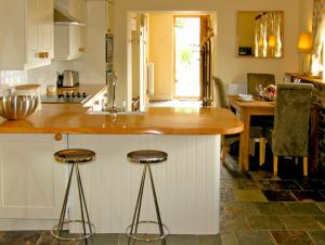 a kitchen with a counter and two bar stools at Valley View in Ross on Wye