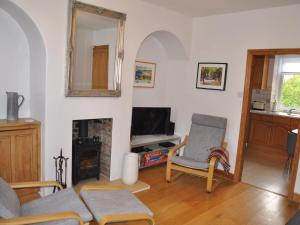 a living room with a couch and a fireplace at Croft Cottage in Pateley Bridge
