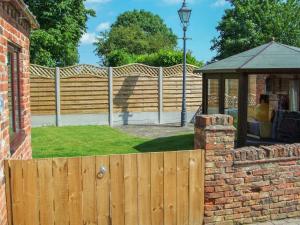 a wooden fence in a yard with a gazebo at Oak Tree Cottage in Beverley