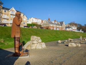 a statue of a man standing in a park at Spindrift in Reighton