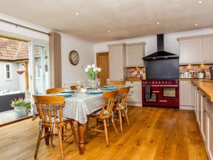 a kitchen with a table and chairs and a stove at The Farm House Nables Farm in Chippenham