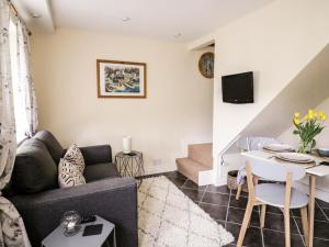 a living room with a couch and a table at October Cottage in Ripon