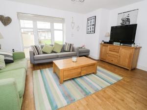 a living room with a couch and a tv at The Bungalow in Pwllheli