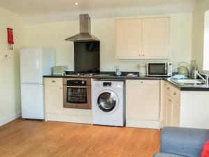 a kitchen with a washing machine and a refrigerator at Oak Tree Cottage in Beverley
