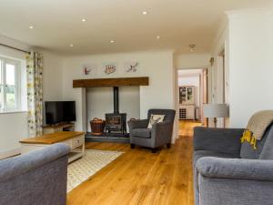 a living room with two couches and a fireplace at The Farm House Nables Farm in Chippenham