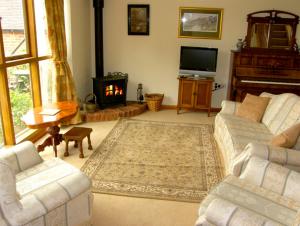 a living room with two couches and a fireplace at The Coach House in Shrewsbury