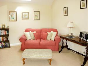 a living room with a red couch and a table at The Byre in Bishops Castle