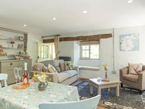 a living room with a couch and a table at Mill Cottage in Tenbury