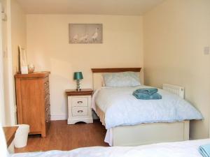 a bedroom with a bed and a dresser and a bed at The Old Dairy in Beverley