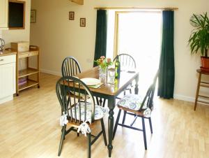 a dining room with a table and chairs and a kitchen at The Byre in Bishops Castle