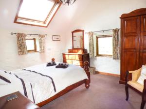 a bedroom with a bed and a dresser and a mirror at The Old Granary in Haverfordwest