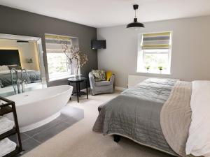 a bedroom with a large bed and a bath tub at The Old Post Office in Garstang