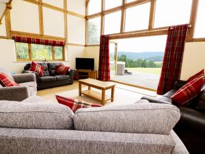 a living room with couches and a large window at The Hayloft in Knighton