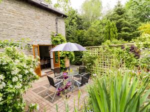 a patio with a table and chairs and an umbrella at The Granary in Bucknell