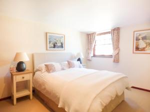 1 dormitorio con cama blanca y ventana en Parlour Cottage en Saint Erth