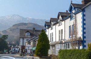 a row of houses in a town with mountains in the background at Swallows Nest in Coniston