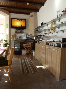 a kitchen with wooden cabinets and a television on the wall at B&B Pension Winzerhaus Zell-Mosel in Zell an der Mosel