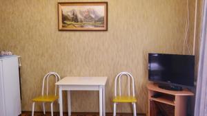 a room with a table and a tv and two chairs at Guesthouse Tatyiana in Sochi