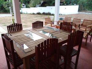 a wooden table with wooden chairs and a table and a table and chairsktop at Cassia Udawalawe in Udawalawe