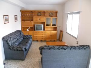 salon z kanapą i telewizorem w obiekcie Miralmar, 10º-69 w mieście Cullera