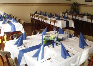 a row of tables with blue napkins and chairs at Landgasthaus Hoffmeister in Hehlen