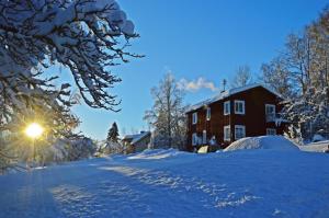 una strada innevata di fronte a una casa di MUSES BNB Bed & Breakfast a Bergvik