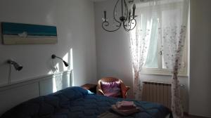 a bedroom with a blue bed and a window at Cà di Boschetti Old Farm f in La Spezia