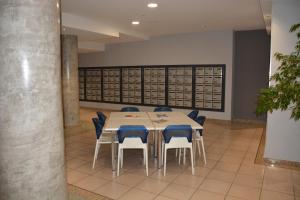 einen Konferenzraum mit einem Tisch und blauen Stühlen in der Unterkunft Appartement T2 de standing au pied des plages in Golfe-Juan