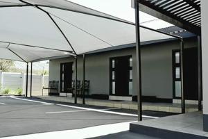 een lege parkeerplaats met een gebouw met een dak bij Ehrlichpark Lodge self catering and spa in Bloemfontein