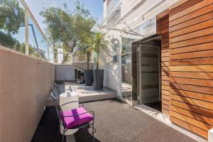 une chaise violette assise sur une terrasse à côté d'un bâtiment dans l'établissement Boutique Hotel Adoral, à Rabac