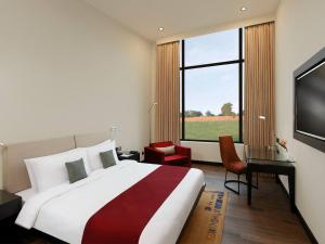 Tiger Palace Resort في بهيراهاوا: غرفة نوم بسرير كبير ونافذة كبيرة