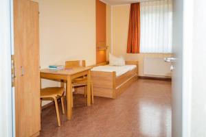 een kamer met een bureau, een bed en een tafel bij DJH Jugendherberge Dresden - Jugendgästehaus in Dresden