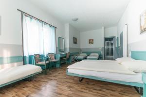 a hospital room with two beds and chairs at Hotel Besso Lugano Center in Lugano