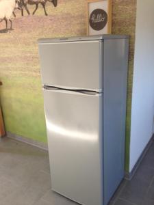 a refrigerator in a room with a picture of a sheep at Gemütliches Apartment nahe Porsche in Weissach