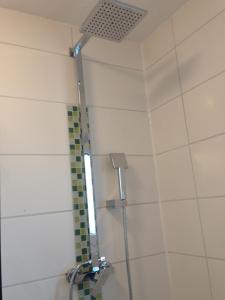 uma casa de banho com chuveiro e cabeça de chuveiro em Gemütliches Apartment nahe Porsche em Weissach