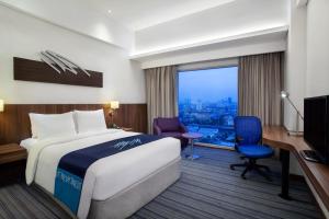 um quarto de hotel com uma cama, uma secretária e um computador em Holiday Inn Express Jakarta Pluit Citygate, an IHG Hotel em Jakarta