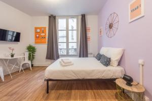 パリにあるApartments WS Hôtel de Ville - Musée Pompidouの小さなベッドルーム(ベッド1台、テーブル付)