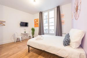 - une chambre avec un lit, une fenêtre et une table dans l'établissement Apartments WS Hôtel de Ville - Musée Pompidou, à Paris
