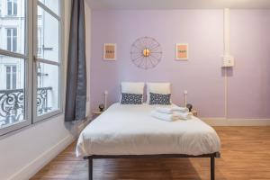 - une chambre avec un lit doté de draps blancs et une fenêtre dans l'établissement Apartments WS Hôtel de Ville - Musée Pompidou, à Paris